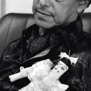 Man holding a rag doll with a little bow in her hair