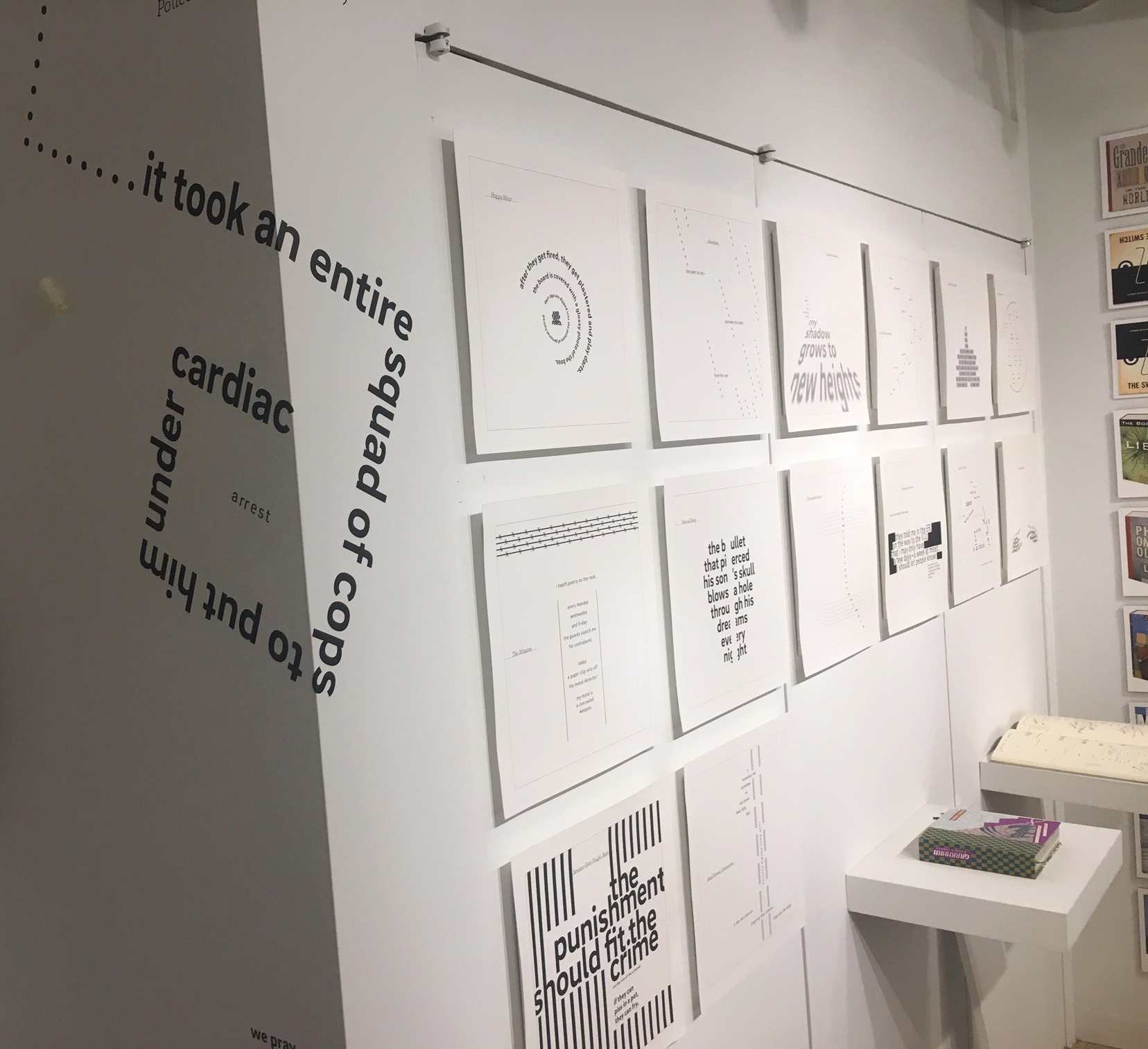 installation of text prints on wall in gallery