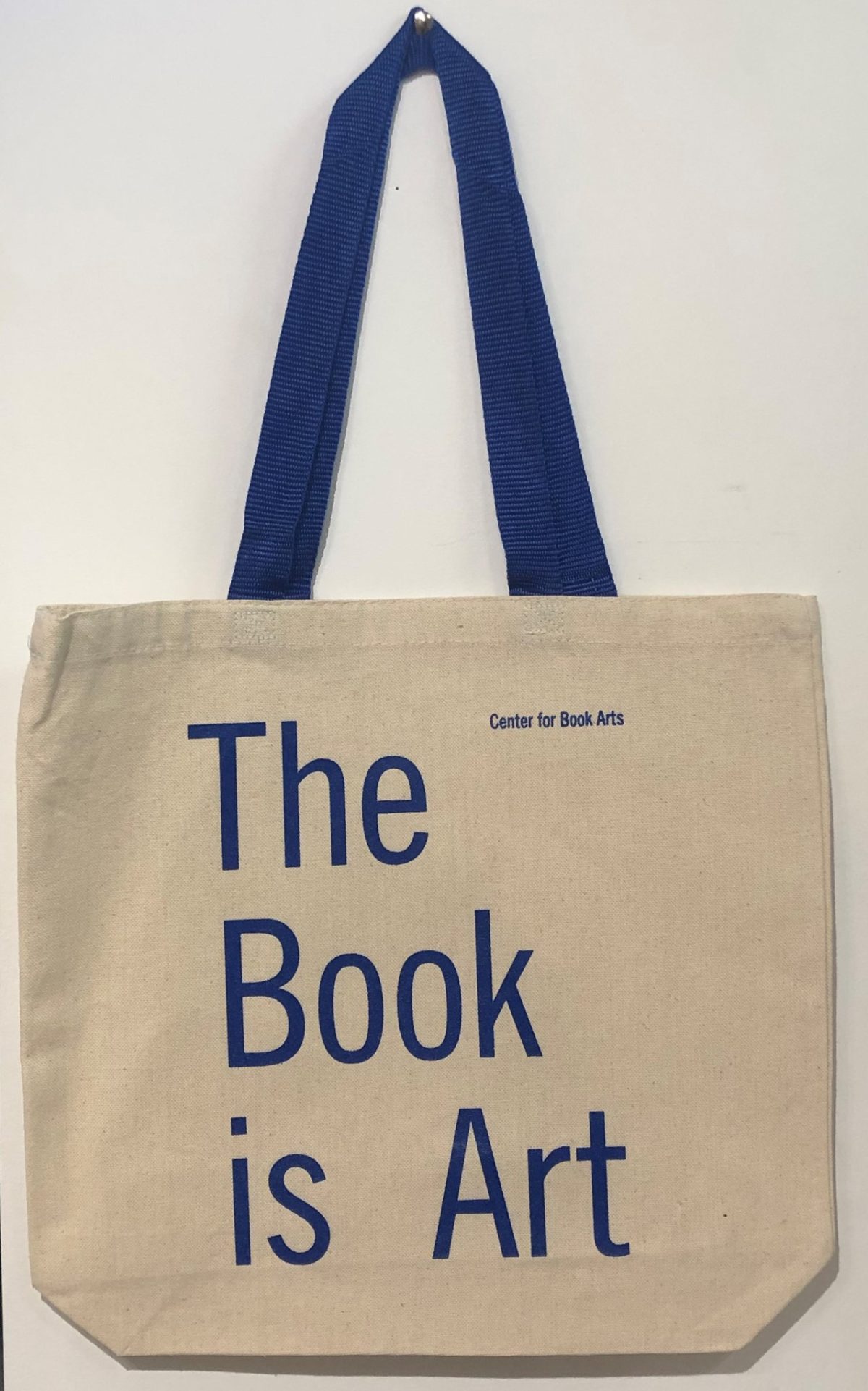 Natural Canvas Tote Bag with blue handles and text saying "The Book is Art"