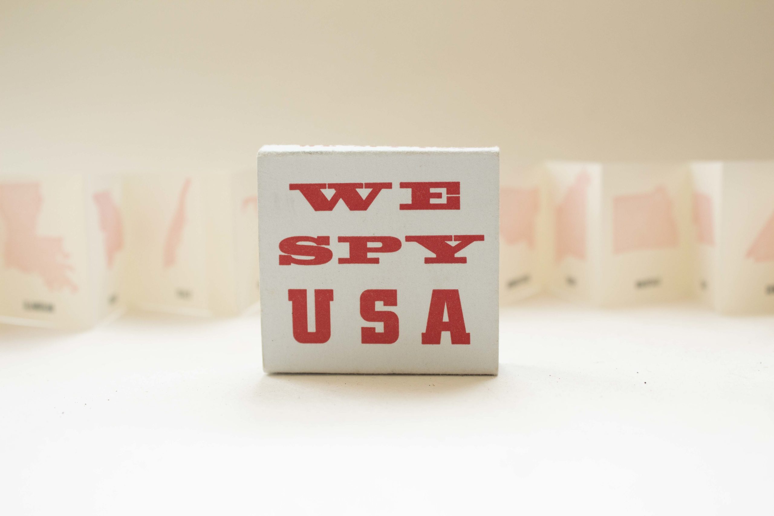 2"x2" book with the words we spy u.s.a. in red on the cover