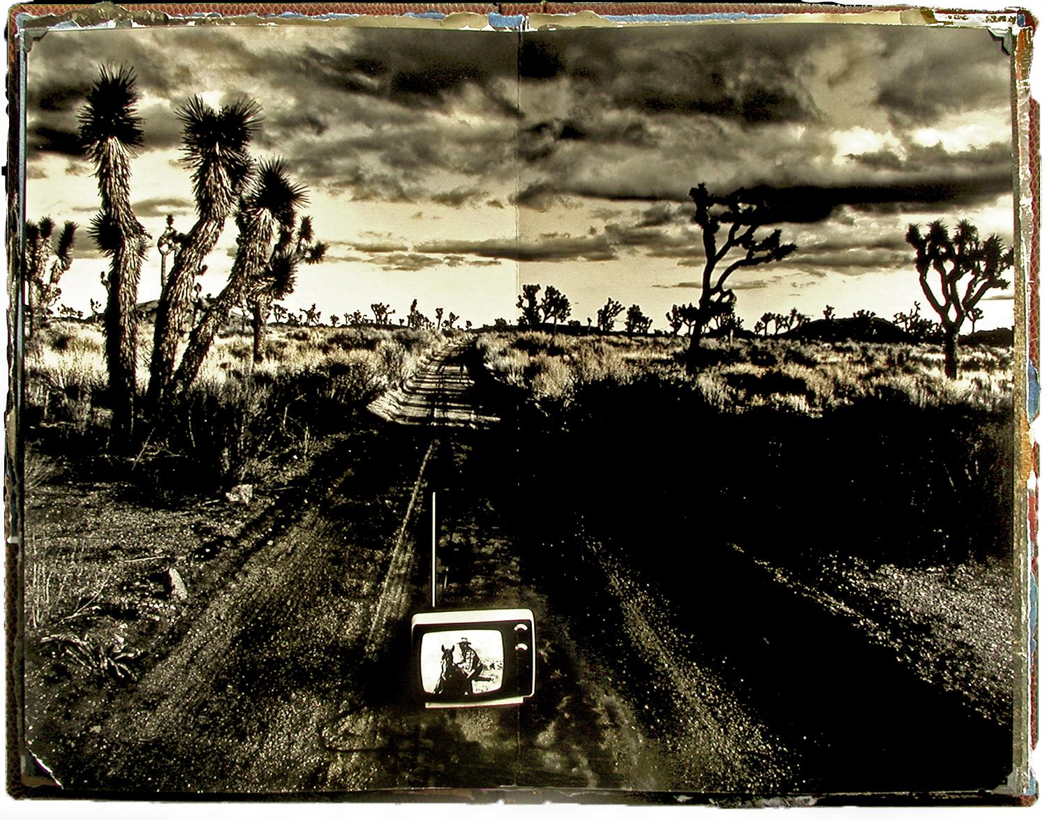 open book spread showing a photo of a television sitting on a desert road