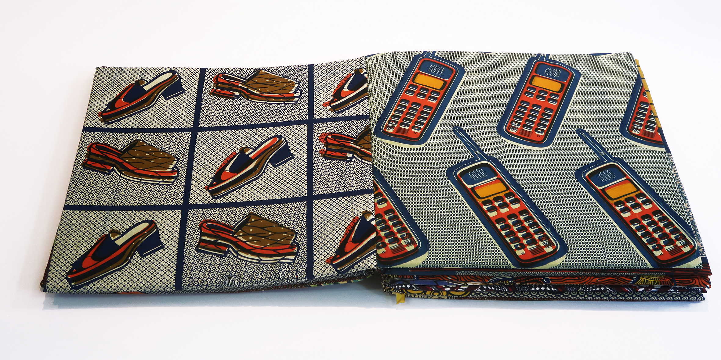 open fabric book with patterns of shoes and cellphones