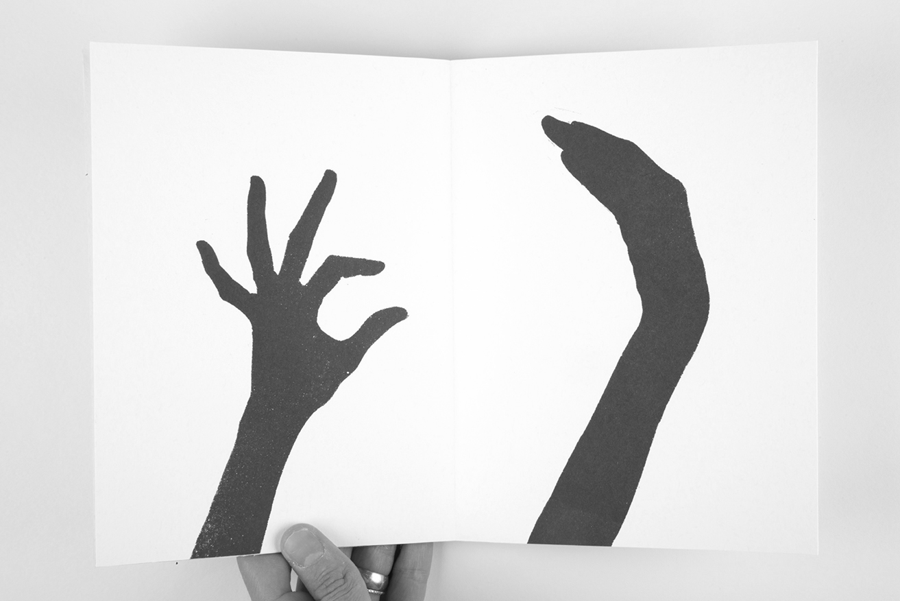 A page spread with two black shillouettes of hands against a white background, failing to properly give a high five