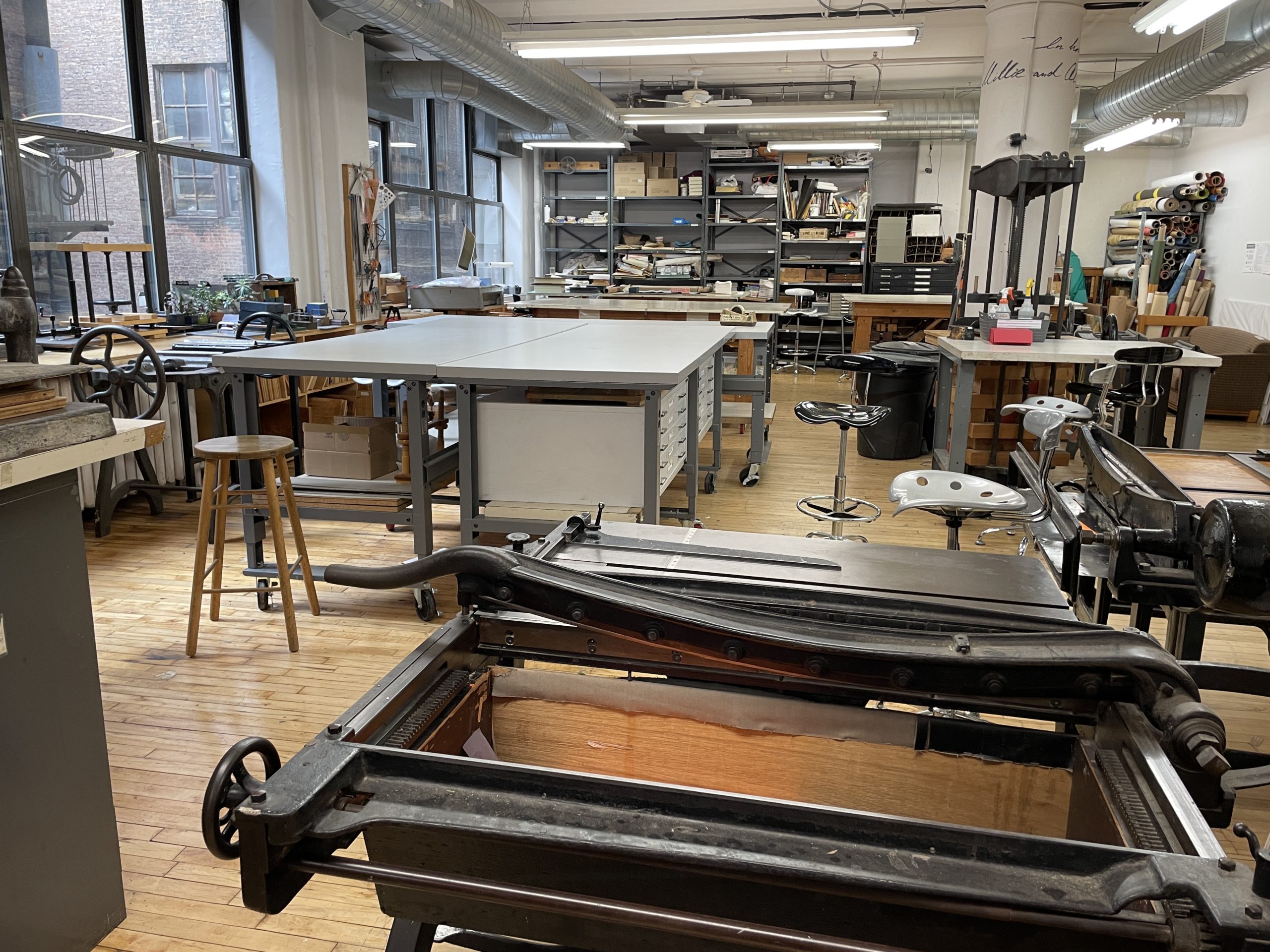 bookbindery with boardshears, tables, and many hand tools and presses