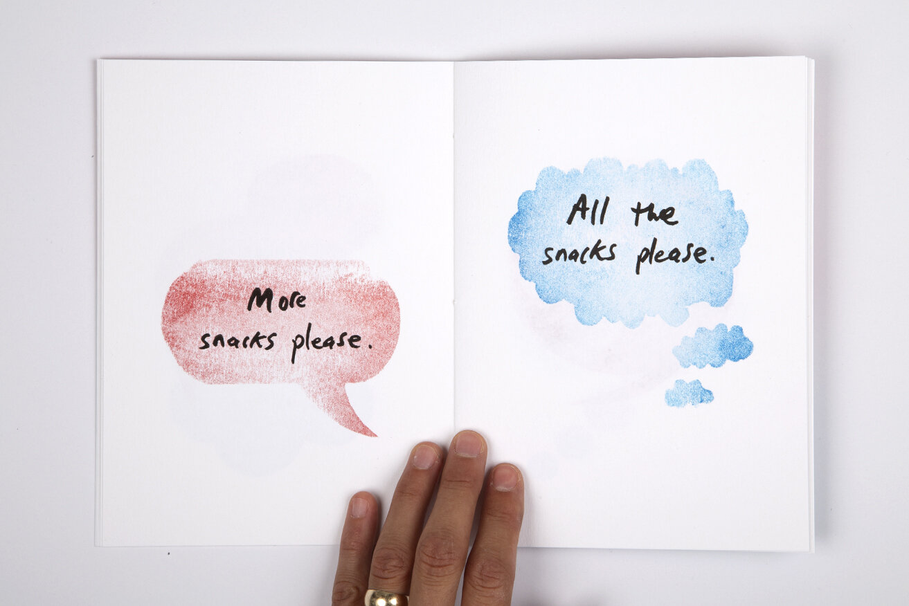 White book over white background. On the right page there is a red watercolor speech bubble with text that reads "More snacks please". On the right page there is a light blue watercolor thought bubble with text that reads: "All the snacks please".