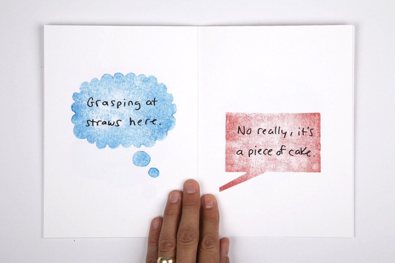 White book over white background. Left page contains light blue watercolor thought bubble that with text that reads "Grasping at straws here". Right page contains a red watercolor speech bubble with text that reads "No really, it's a piece of cake".