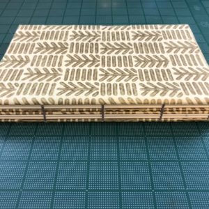 Patterned coptic notebook placed on a cutting mat.
