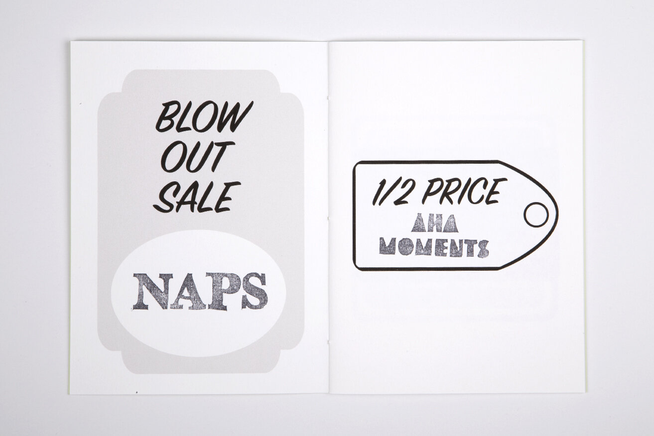 Open white book over white background. Left page shows a stamped-like grey price tag containing the words "Blow Out Sale: Naps" in caps. The right page shows a stamped-like white price-tag containing the words "1/2 Price: Aha Moments" in caps.