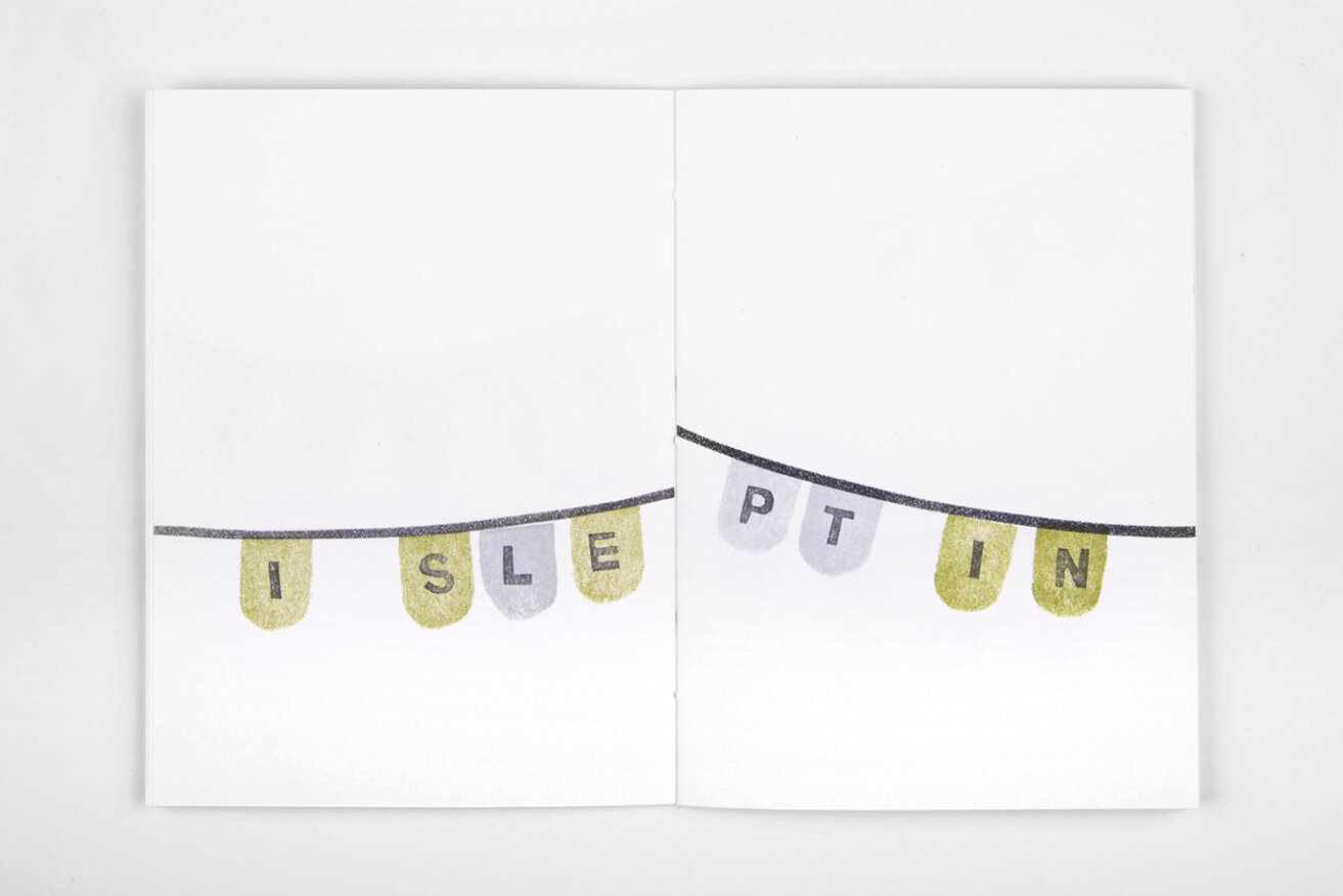 Open white book over white background. Across the two pages, there is a party garland containing the text "I slept in".