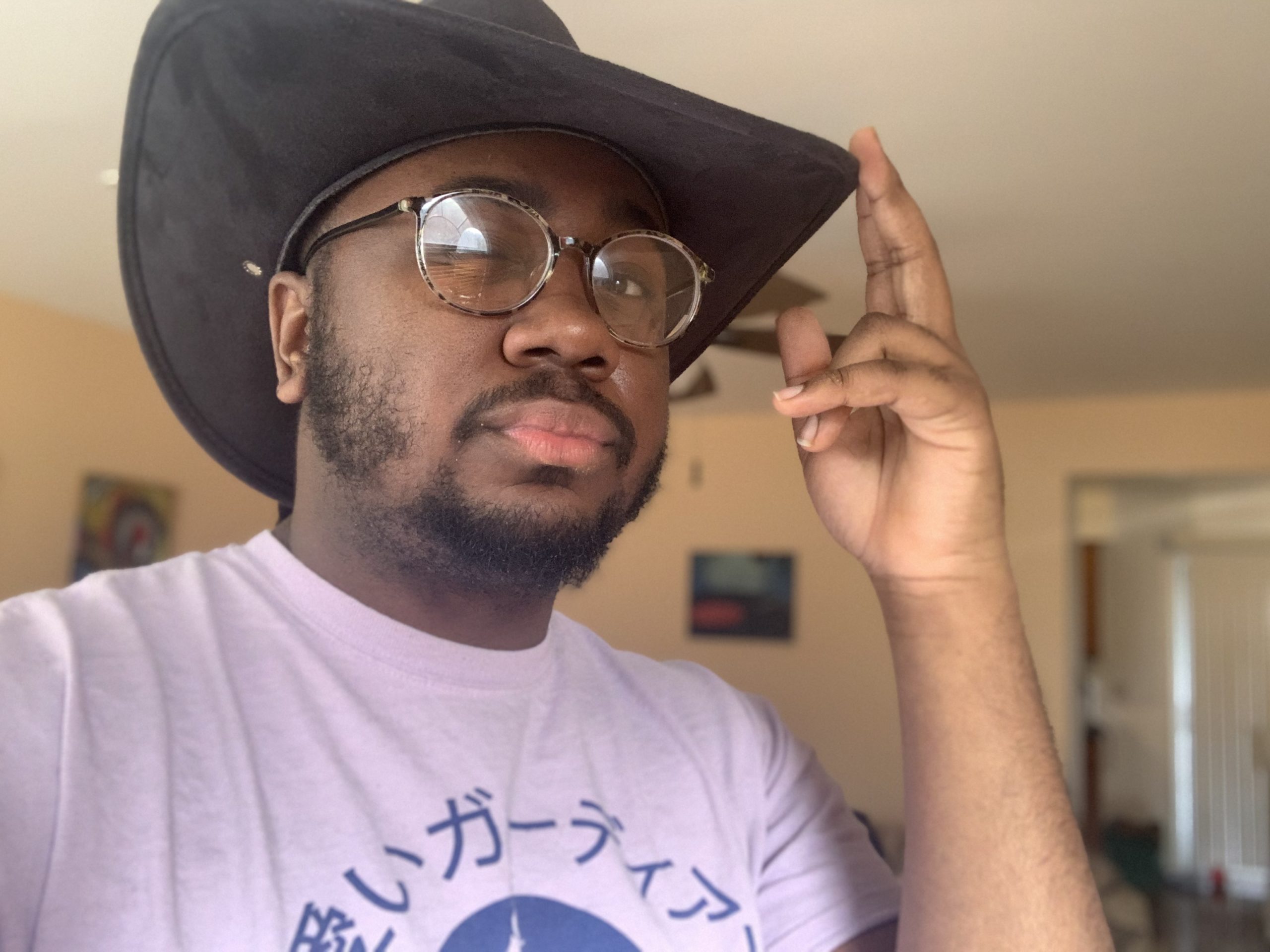 Dark skin male in cowboy hat with glasses