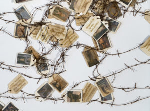 Several hang tags with images of people and text connected by reddish brown string tied together