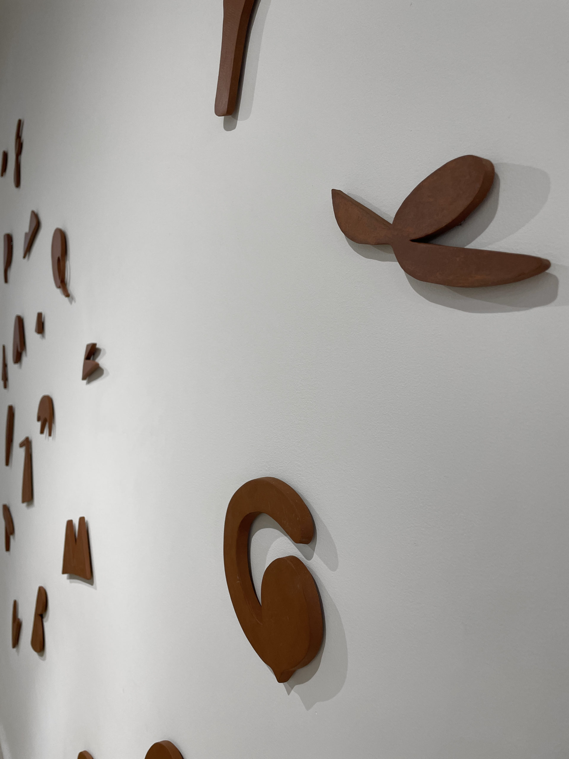brown ceramic shapes scattered on the wall