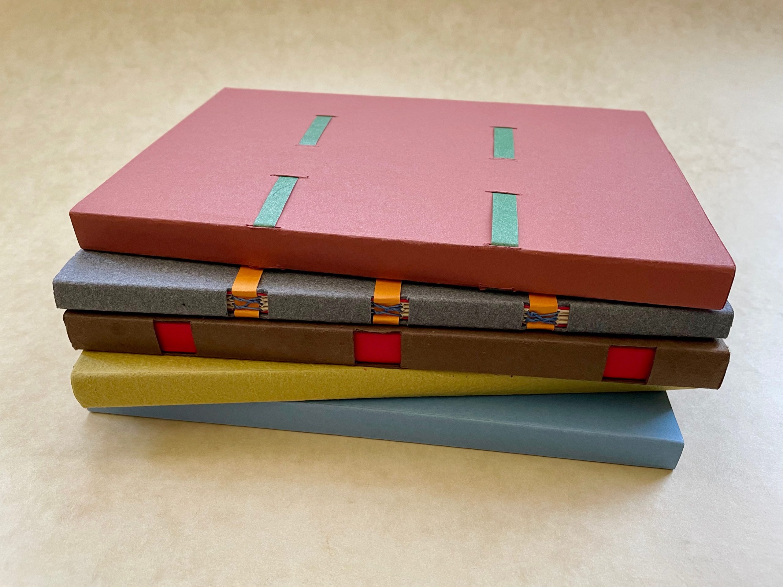 stack of hand-made books with paper case binding