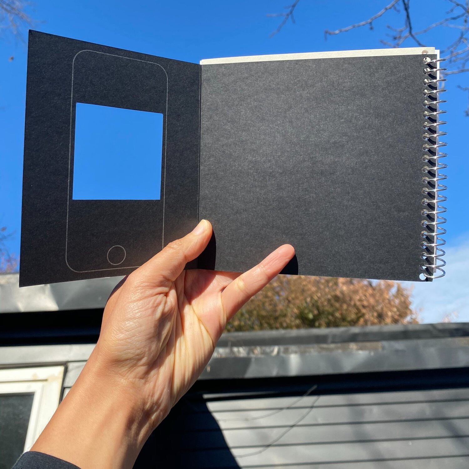 book held up against the blue of the sky