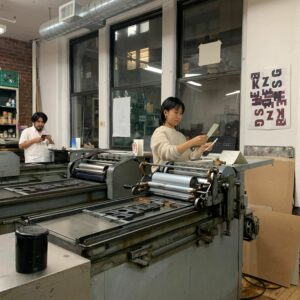 A view of the CBA printshop with Caslon working on the Number 4 in the foreground and Oswaldo working on the Uni 1 in the background.