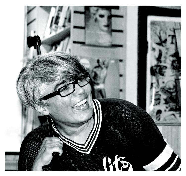 Black and white image of Beldan Sezen laughing. She is wearing glasses and a sports jersey.