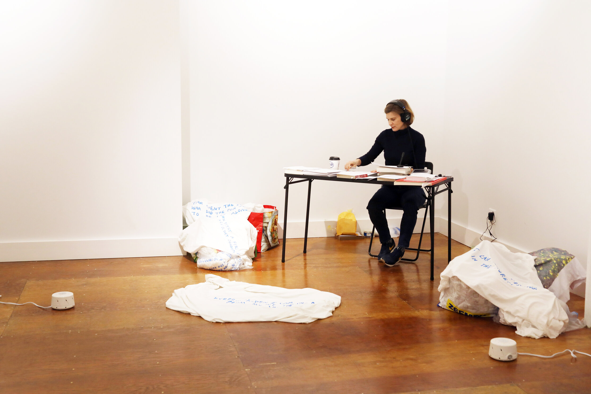 Jennifer Schmidt at a table in the far corner of a bright room with white walls and a hardwood floor